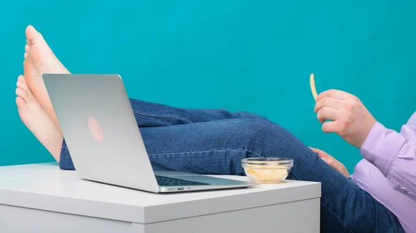 Primo piano di gambe maschili su un desktop vicino a un computer portatile. Il concetto di noia e stanchezza sul lavoro . — Foto Stock