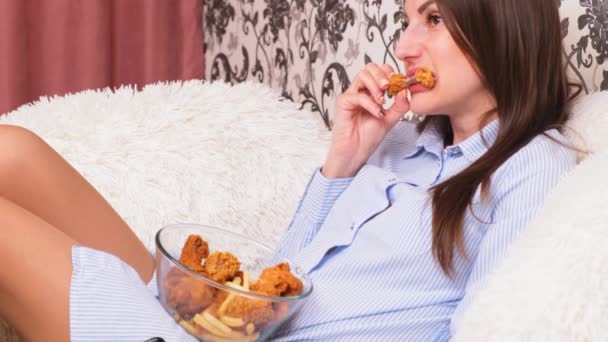 Joven mujer feliz comiendo pollo frito, primer plano. La mujer come alitas de pollo, ingesta de calorías y riesgos para la salud, colesterol — Vídeo de stock