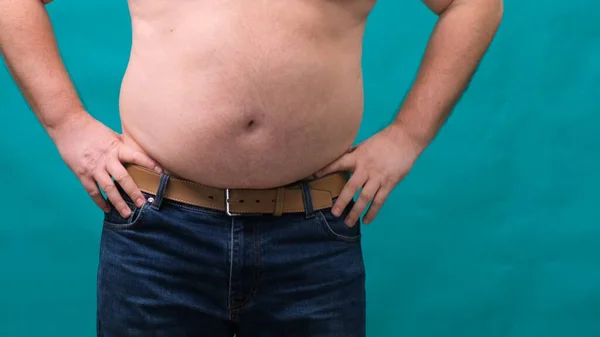 Rüde mit dickem Bauch zeigt sein Fett auf einem grünen Bildschirm. Das Konzept der gesunden Ernährung und Abnehmen, Ernährung — Stockfoto