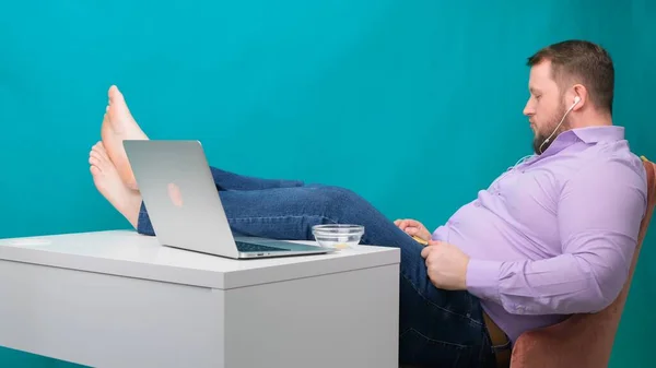 Joven tomando música de ocio y escuchando mientras está sentado en la oficina. El diseñador masculino se sentó tranquilamente en su lugar de trabajo — Foto de Stock