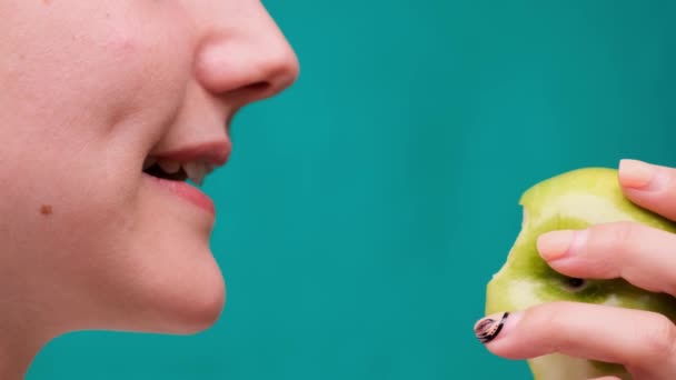 Egészséges táplálkozás és egészséges fogak vagy étrend, fiatal nő harap egy friss alma a zöld képernyőn közelkép — Stock videók