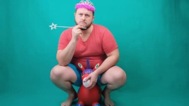 Elinde sihirli bir değnekle tek boynuzlu ata binen pembe tişörtlü, yakışıklı, sakallı, ucube bir adam üzgün. Bir dileği gerçekleştirmek için komik bir sihirbaz şakası..