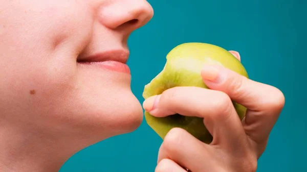 Egészséges táplálkozás és egészséges fogak vagy étrend, fiatal nő harap egy friss alma a zöld képernyőn közelkép — Stock Fotó