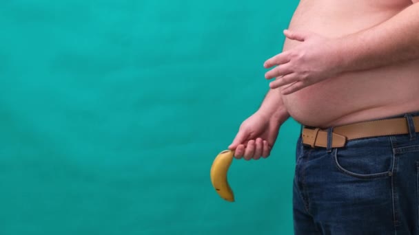 Старый хромой опускающийся банан висит на генитальной области одетый неузнаваемый человек, импотенция эректильной дисфункции или хромой член концепции . — стоковое видео