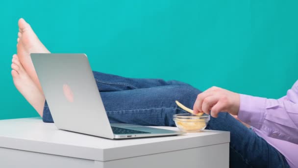 Närbild av manliga ben på ett skrivbord nära en bärbar dator. Begreppet tristess och trötthet i arbetet. — Stockvideo
