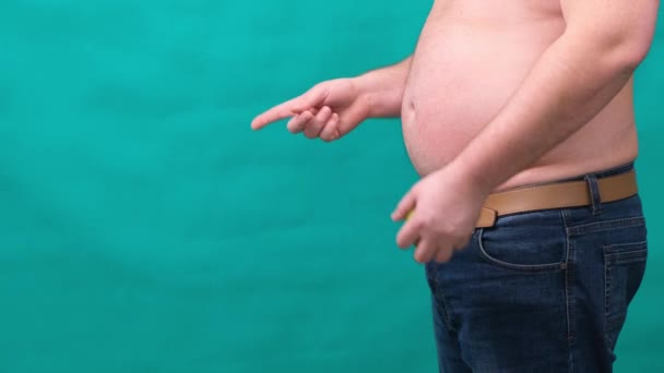 Жирний чоловік з великим животом тримає в руці зелене яблуко. Концепція здорового харчування і схуднення, дієта . — стокове відео