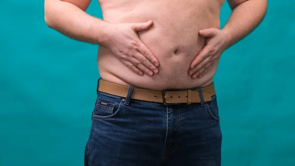 Rüde mit dickem Bauch zeigt sein Fett auf einem grünen Bildschirm. Das Konzept der gesunden Ernährung und Abnehmen, Ernährung — Stockfoto