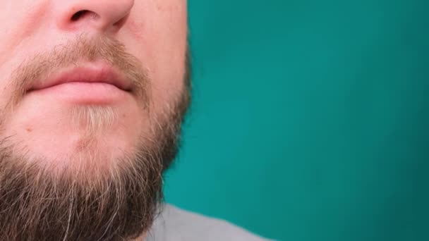 Close-up van mannelijke bebaarde gezicht en mond op groen scherm, kopieer ruimte. — Stockvideo