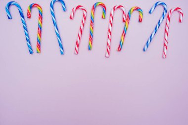 Pembe arka planda bir sürü renkli baston şeker, kopyalama alanı