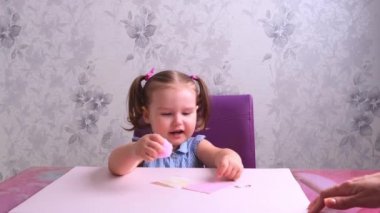 Küçük kız, annesiyle birlikte yumuşak, pembe bir domuz yapar. Her gün anneler, çocuklarla el işi yapar..