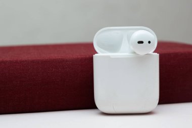 Fotokopi alanı olan eski bir kitaptaki kablosuz kulaklıklar, sesli kitap konsepti, kendi kendine çalışma.