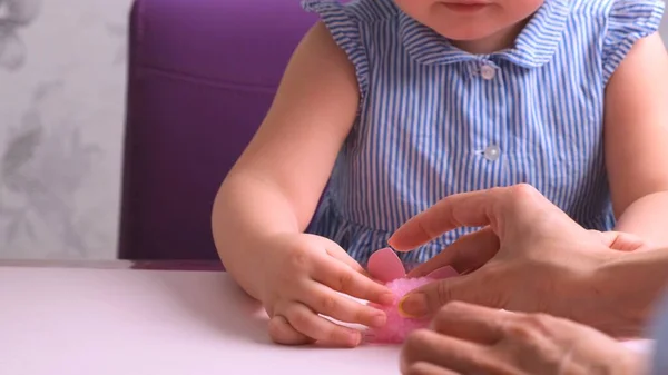 Klein meisje, samen met haar moeder, maakt een zacht speeltje roze varken. Dagelijkse moeders, ambacht met kinderen. — Stockfoto