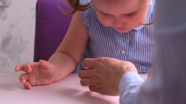 Klein meisje, samen met haar moeder, maakt een zacht speeltje roze varken. Dagelijkse moeders, ambacht met kinderen. — Stockvideo