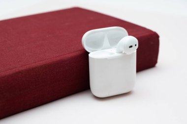 Fotokopi alanı olan eski bir kitaptaki kablosuz kulaklıklar, sesli kitap konsepti, kendi kendine çalışma.