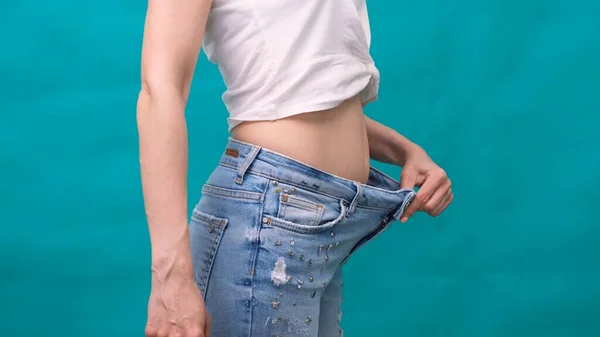 Attraktive junge Frau in Jeans und mit schlankem Körper nach dem Sport und gesunder Ernährung. Konzept zur Gewichtsreduktion. — Stockfoto