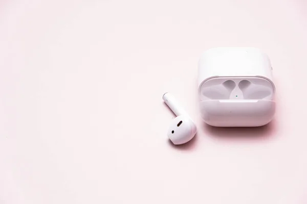 Słuchawki bezprzewodowe na różowym tle. Bezprzewodowy zestaw słuchawkowy izolowany — Zdjęcie stockowe