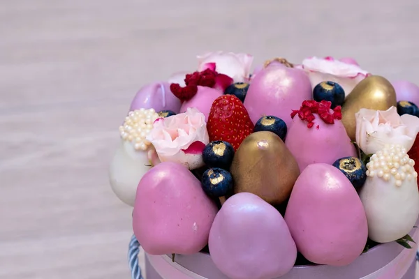 Het mooiste boeket verse aardbeien in witte, roze en gouden chocolade op een lichte achtergrond. — Stockfoto