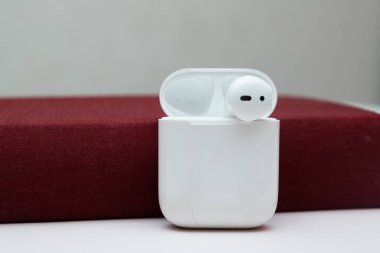 Fotokopi alanı olan eski bir kitaptaki kablosuz kulaklıklar, sesli kitap konsepti, kendi kendine çalışma.