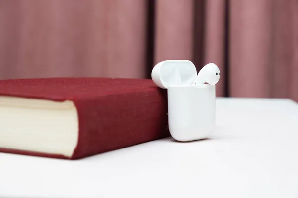 Słuchawki bezprzewodowe w starej książce z przestrzenią do kopiowania, koncepcja audiobooka, samodzielna nauka. — Zdjęcie stockowe