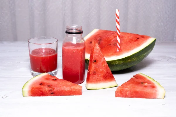 Vitamina melancia smoothie e fatias de melancia vermelha fresca em um fundo de mesa de madeira branca. espaço de cópia — Fotografia de Stock