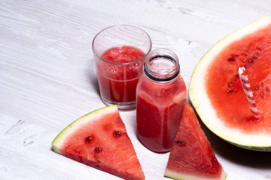 en güzel karpuz smoothie ve beyaz ahşap masa zemininde taze kırmızı karpuz dilimleri. Boşluğu kopyala