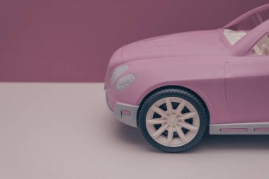Pembe arka planda pembe bir araba. Araba satışı, araba kiralama veya araba kiralama kavramı.
