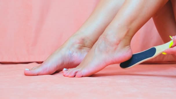 Kobieta pocierająca obcasy stopami, robiąca pedicure. Ręka pięknej i eleganckiej zadbanej dziewczyny dotykającej jej nogi. Spa, peeling i pielęgnacja stóp. — Wideo stockowe