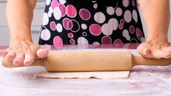 Massa de cozinhar com um rolo na mesa. A trabalhar na padaria. Avó cozinheiro na cozinha prepara massa de farinha, conceito de comida, dieta e bio. — Fotografia de Stock