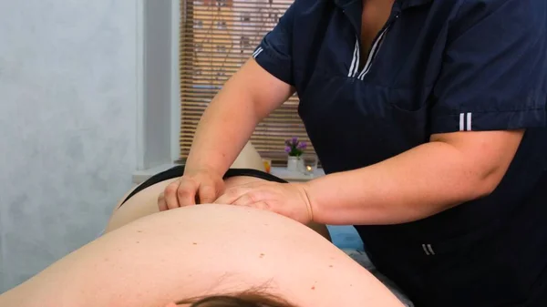 Anti-cellulitis massage voor een dikke vrouw. Agressieve strijd tegen vet. Kuuroord. — Stockfoto