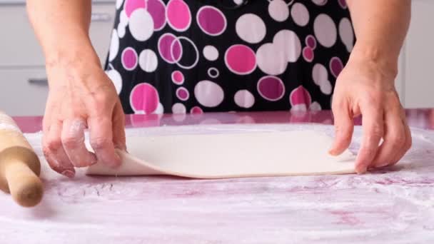 Cocinar la masa con un rodillo en la mesa. Trabajando en la panadería. La abuela cocinera en la cocina prepara masa a partir de harina, concepto de comida, dieta y bio. — Vídeo de stock