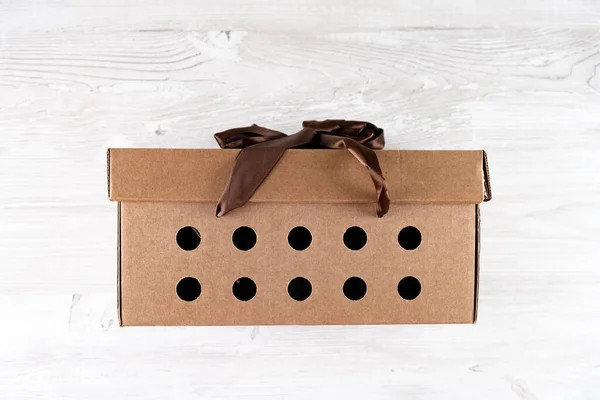 Ajándék karton doboz barna íj fehér fa asztal, szállítási szolgáltatás koncepció — Stock Fotó