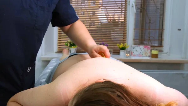 Terapötik sırt masajı. Masaj terapisti bir kadına masaj yapıyor. Vücut bakımı kavramı — Stok fotoğraf