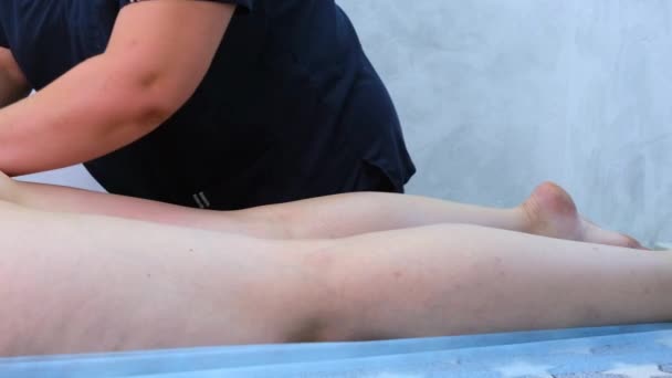 Therapeut maakt een anti-cellulitis massage. masseur masseren dikke vrouwelijke benen in de schoonheidssalon. Schoonheidsbehandeling concept. close-up — Stockvideo