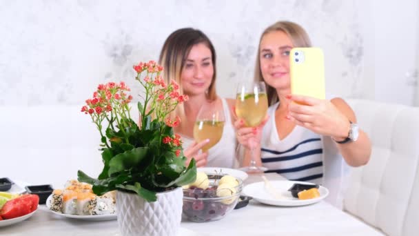 Dwie dziewczyny śmiejące się dziewczyny rozmawiające przez komunikację wideo na smartfonie w domu, selektywne skupienie — Wideo stockowe