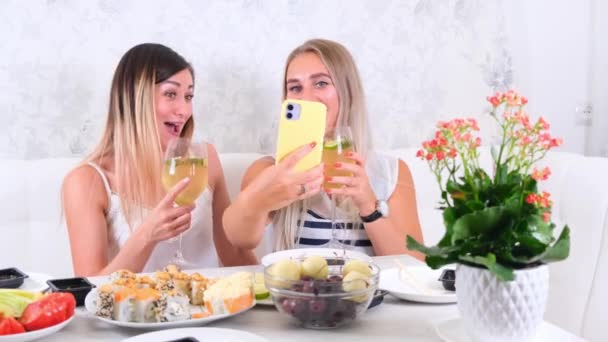 Due ragazze ridenti che parlano in video comunicazione su smartphone a casa, focus selettivo — Video Stock