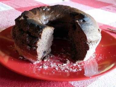 Kırmızı bir tabak içinde çikolatalı pasta dilimlenmiş