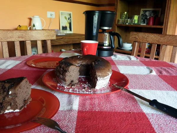 Kırmızı bir tabak içinde çikolatalı pasta dilimlenmiş