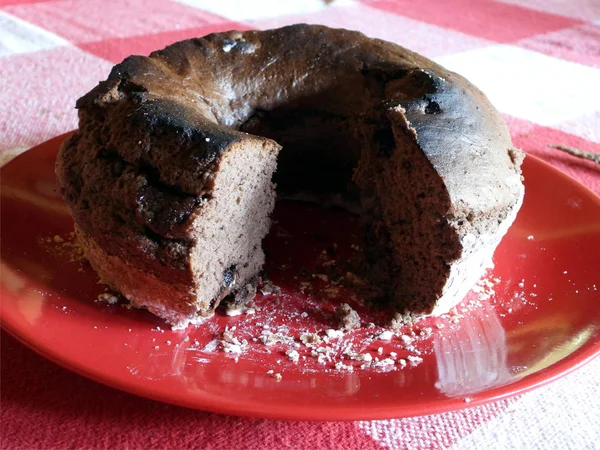 Kırmızı bir tabak içinde çikolatalı pasta dilimlenmiş