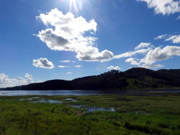 Güneş, bulutlar, hill ve göl su