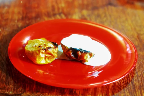 kırmızı plaka üzerinde ekşi krema ile kavrulmuş armut