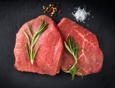 Siyah arka plan üzerine biberiye ile taze çiğ et