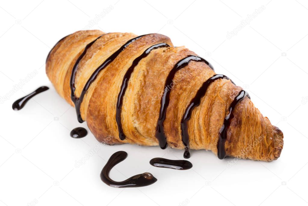 Freshly baked croissant decorated with chocolate sauce