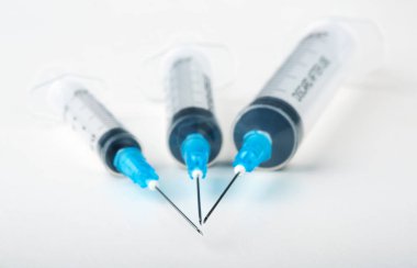 Beyaz zemin üzerinde üç plastik şırınga