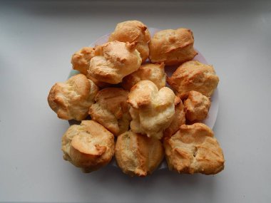 Lezzetli kek çanak üzerinde vardır. Eklerleri pişmiş ve krema ile dolu. Yakında, her pasta çikolata fudge ele alınacaktır. Onlar un, tavuk yumurta, tereyağı, yoğunlaştırılmış süt, su, banyo yapılmıştır,