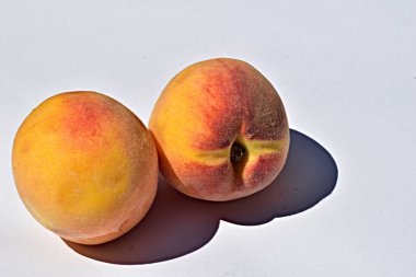 Olgun, sulu pembe şeftaliler masada bir tabağa konur..