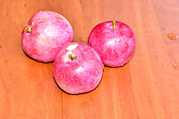 Τρία Ροζ Ώριμα Μήλα Κείτονται Μια Επίπεδη Καφέ Επιφάνεια — Φωτογραφία Αρχείου
