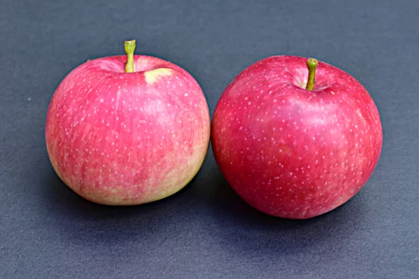 Δύο Κόκκινα Μήλα Κείτονται Μαύρο Τραπέζι — Φωτογραφία Αρχείου