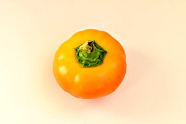 Beyaz masa yüzeyinde sarı dolma biber uzanır..