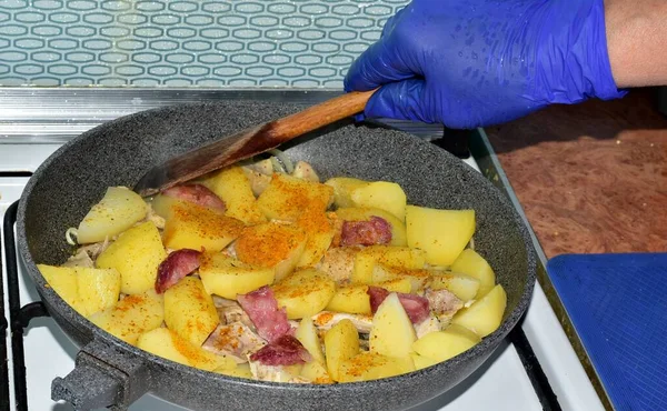 Hostess Stirring Fried Potatoes Wooden Spoon — Stock Photo, Image