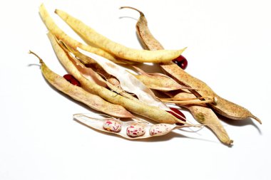 Beyaz arka planda bir sürü olgun fasulye yatar..